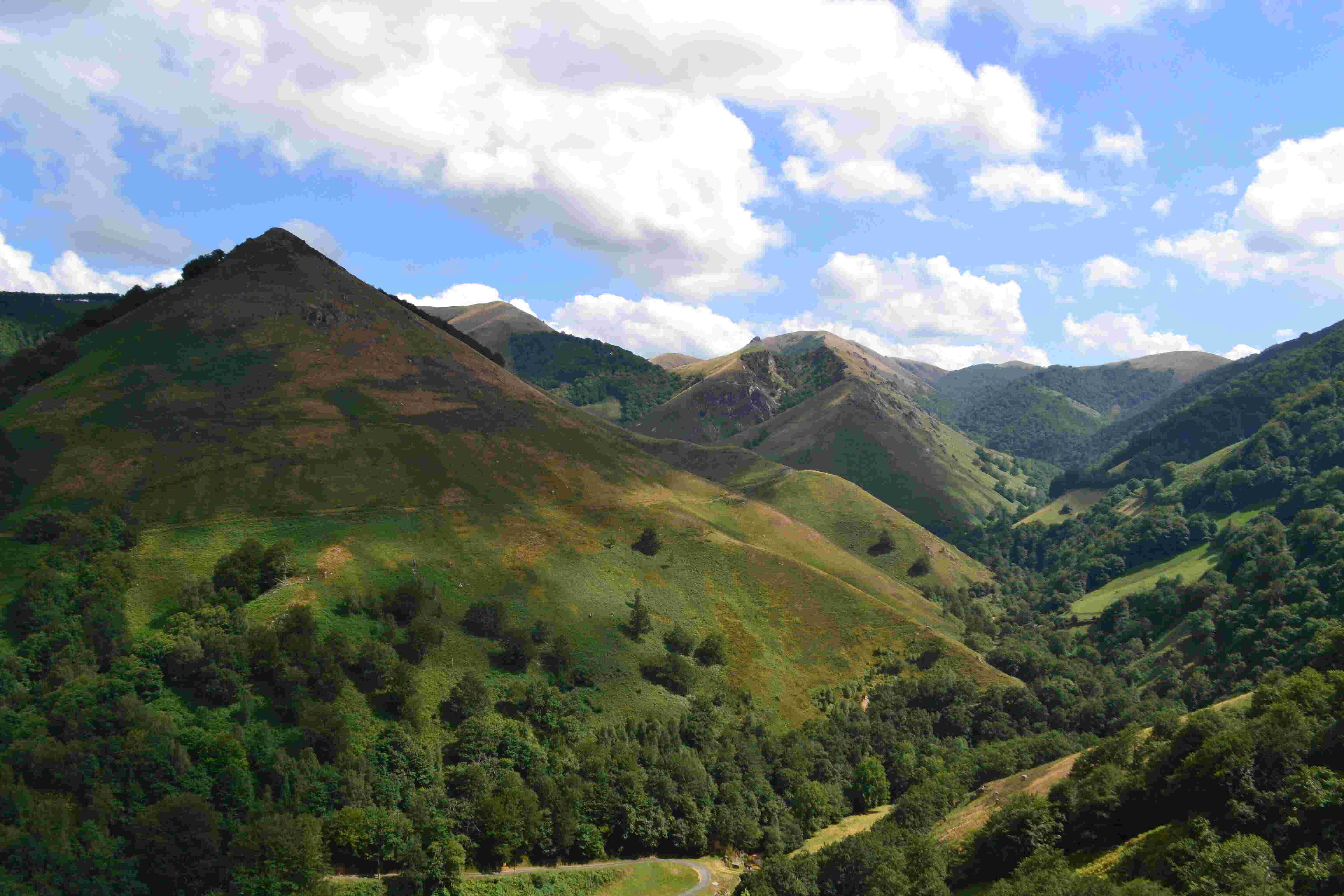 Montagnes verdoyantes sous un ciel parsemé de nuages