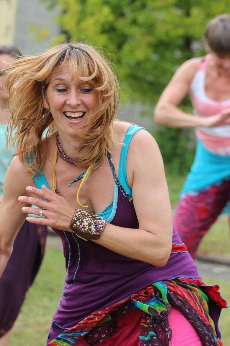 Véronique Linclau dansant en plein air, souriante, cheveux au vent